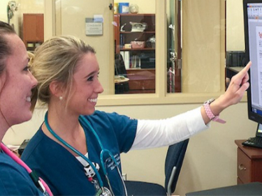 Nurses reviewing patient status screen