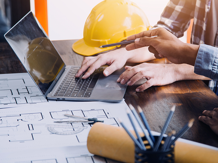 Contractor reviewing documents on computer